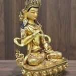 Left three-quarter view of Vajrasattva statue, 24K gold-plated copper and gold-powder face, bell at hip, fine hand-chased details.