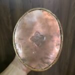 Underside of Guru Rinpoche statue base showing copper sealing plate and sacred stamp.