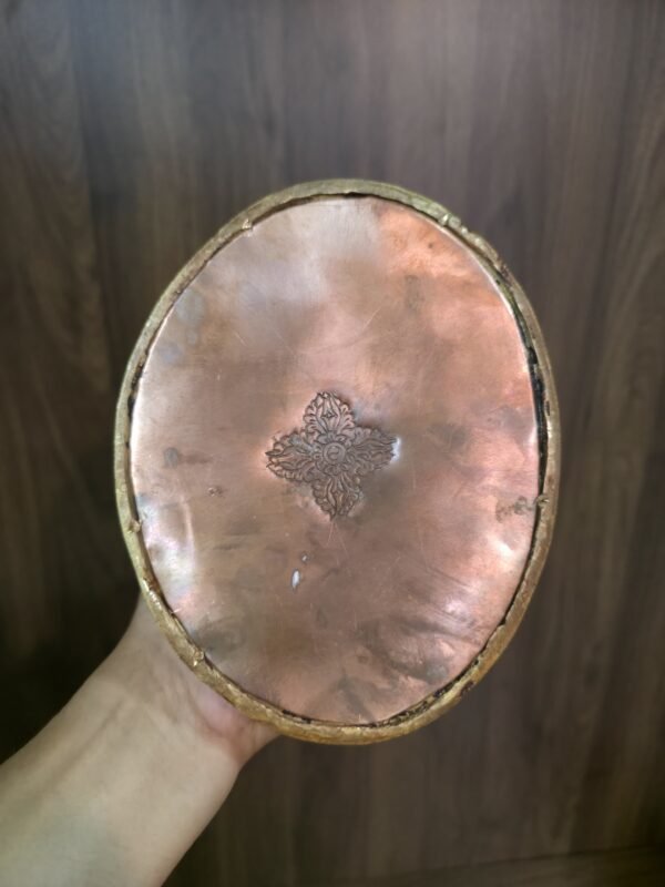 Underside of Guru Rinpoche statue base showing copper sealing plate and sacred stamp.