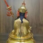 Back view of the Guru Rinpoche statue showing detailed engravings on the robes and the back of the lotus hat.