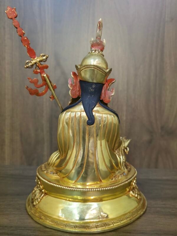 Back view of the Guru Rinpoche statue showing detailed engravings on the robes and the back of the lotus hat.