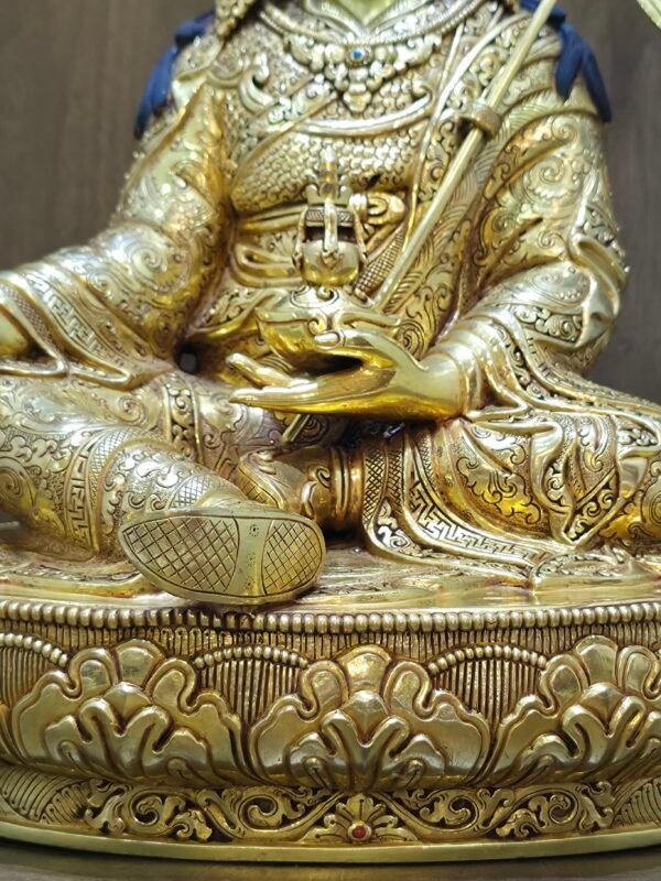 Detail macro shot of the statue's torso showing the golden skull cup held at the heart and intricate jewellery.