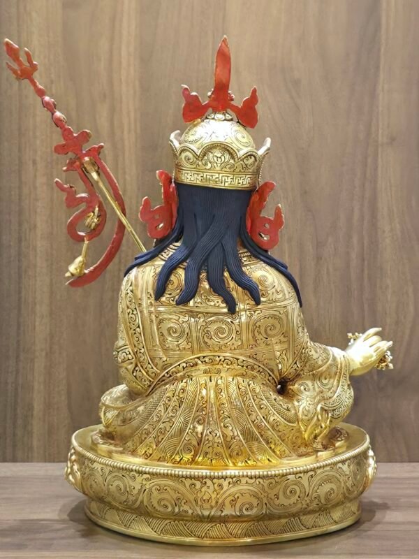 Back view of gold Guru Rinpoche statue showcasing the detailed engravings on the robes and flowing hair.
