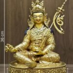 Full front view of 24K gold plated Guru Rinpoche statue seated on a lotus base with khatvanga staff showing the measurements and weight.