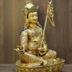 Angled view of 24K gold plated Buddhist deity statue showing the skull cup (Kapala) and ornate jewelry settings.