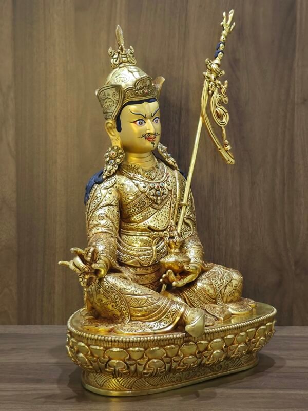 Angled view of 24K gold plated Buddhist deity statue showing the skull cup (Kapala) and ornate jewelry settings.