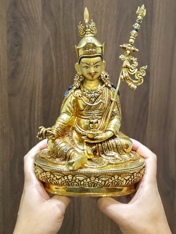 Hands holding 25cm Guru Rinpoche statue to demonstrate 1.6kg weight and scale for home display.