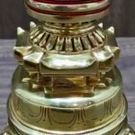 Midsection detail of gold-plated copper chorten with stepped base and red-banded body.