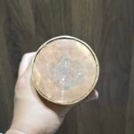 Underside of openable gold-plated copper stupa base with engraved double vajra, shown in hand.