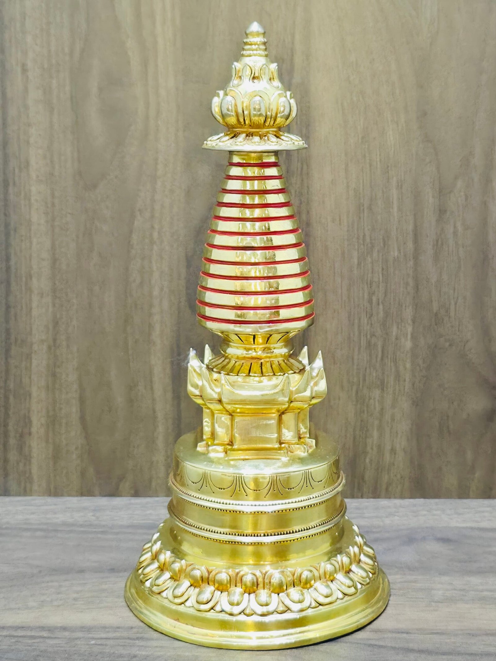 S003-4:3-2 Gold-plated copper Tibetan stupa chorten with red banded spire rings, straight-on product photo on wood backdrop.