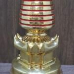 Detail of stupa pedestal and lotus base, gold-plated copper craftsmanship with red-ringed spire above.
