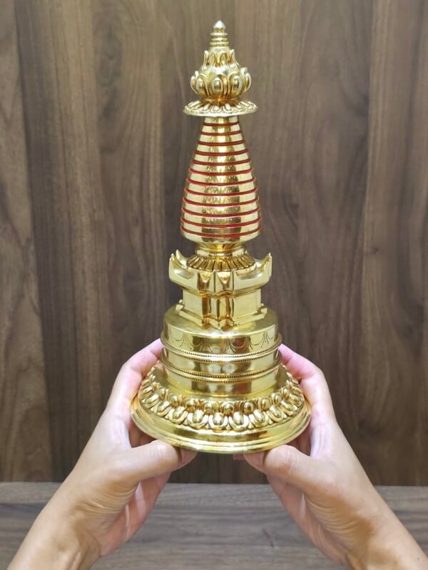 Handheld size view of Tibetan stupa chorten (29 cm tall), 24K gold-plated copper with red spire rings.
