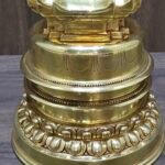 Close up of stupa base with engraved banding and lotus petal border in polished gold plated copper.