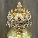Close up of stupa canopy with bead fringe and blue and coral inlays, topped with stacked jewel finial.
