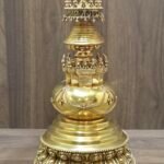 Back view of gold plated copper stupa showing smooth rounded body with applied garlands and stepped pedestal base.