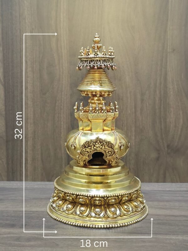 Gold plated copper Buddhist stupa with on image measurements showing 32 cm height and 18 cm base width.