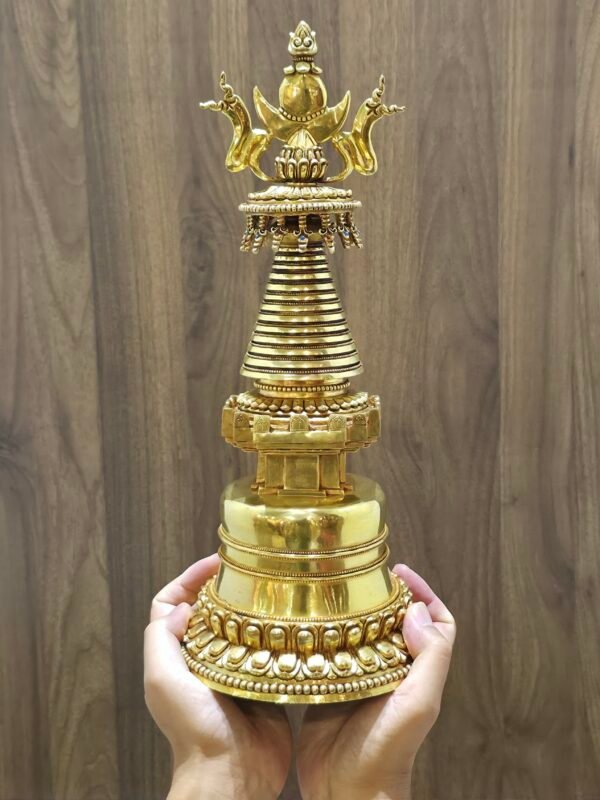 Stupa held in hands for scale, gold plated copper, 38 cm tall and 15 cm wide, substantial 2.7 kg weight.