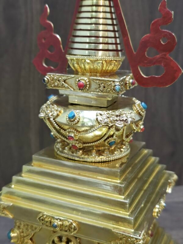 Angled close up of the mid section of the back showing raised ornament work and coloured inlay dots on the band beneath the spire.