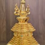 Three quarter view of the full stupa showing the tiered square base, engraved panels, inlay accents, and balanced altar ready silhouette.