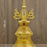 Straight on full view of the gold plated Tibetan style stupa with measurement labels showing 48 cm height, 23 cm width, and 3.250 kg weight on a wood background.