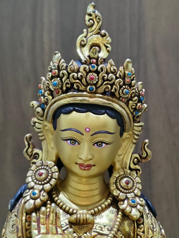 Close-up of Princess Mandarava's face, meticulously painted with pure gold powder, featuring a turquoise-inlaid crown.