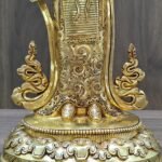 Detailed view of the intricate hand-chased floral engravings on the gold plated skirt of the Yeshe Tsogyal statue.