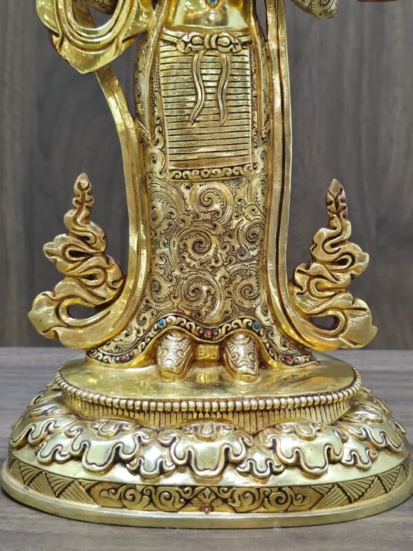 Detailed view of the intricate hand-chased floral engravings on the gold plated skirt of the Yeshe Tsogyal statue.