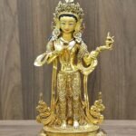 Front view of gold plated Mandarava statue, standing gracefully on a lotus base.
