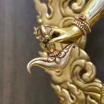 Macro close-up of the Vajrayogini statue's right hand holding the kartika, a curved flaying knife symbolizing the severing of ego and ignorance.