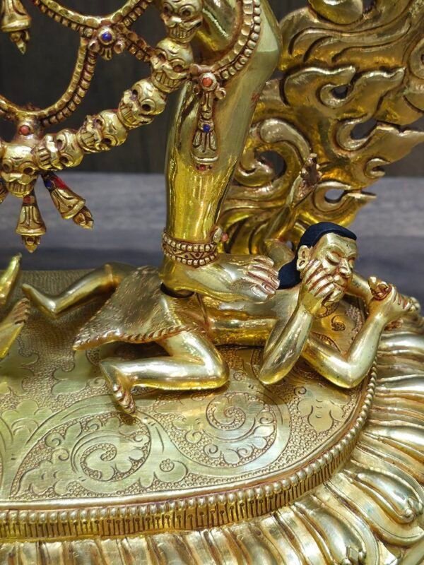 Detailed close-up of the Vajrayogini statue base showing the trampling of prostrate figures on a lotus pedestal.