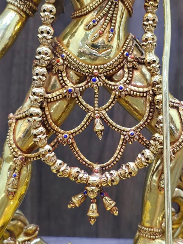 Macro detail of 24K gold plated Vajrayogini statue showing intricate bone apron, skull garland, and gemstone inlays on the waist.