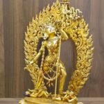 Side view of the Vajrayogini sculpture highlighting the intricate carvings and the Khartang (Khatvanga) staff.