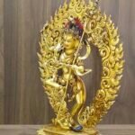 Right view of Dorje Phagmo Vajravarahi statue showing side profile, gold plated body, detailed halo scrollwork and staff.