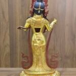 Rear view of Yeshe Tsogyal statue showing engraved robe, open back cavity, and flowing scarf forms.