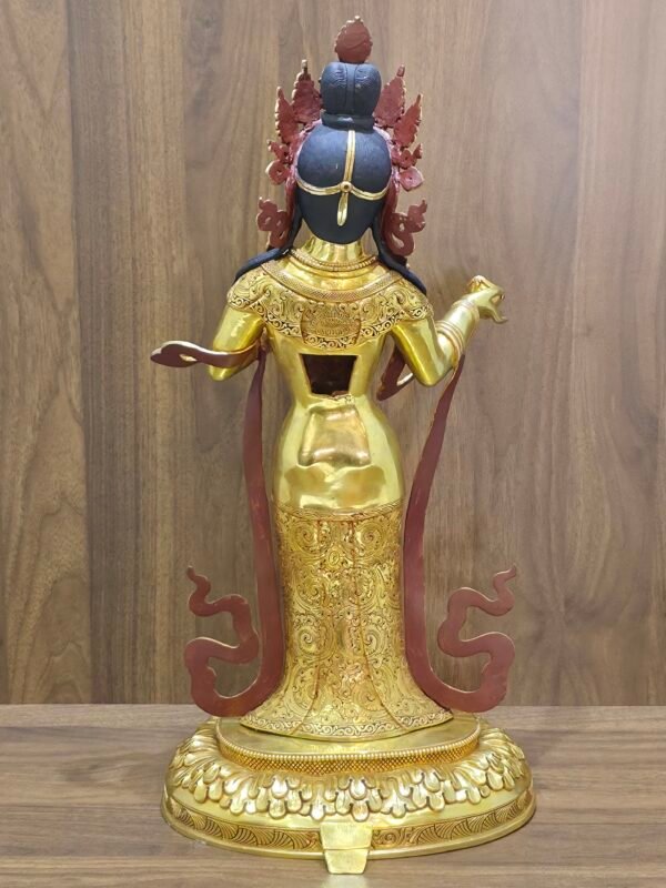 Rear view of Yeshe Tsogyal statue showing engraved robe, open back cavity, and flowing scarf forms.