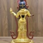 Rear view of Mandarava statue showing engraved back robes, open back cavity, and ritual vase in hand.