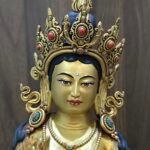 Extreme close-up of Mandarava face, meticulously hand-painted with pure gold powder on the warm copper base.