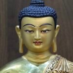 Detailed portrait of the Buddha’s face, hand-painted with pure gold powder to create a soft, meditative "Cold Gold" finish.