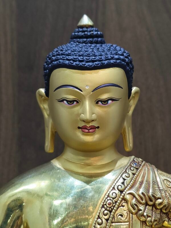Detailed portrait of the Buddha’s face, hand-painted with pure gold powder to create a soft, meditative "Cold Gold" finish.