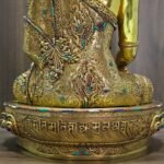 Rear lower view of Crown Shakyamuni Buddha statue showing engraved robe, decorated base and inscription detail.