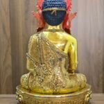 Rear view of Crown Shakyamuni Buddha statue showing engraved robe, red back ornament and inscription on the gold plated base.