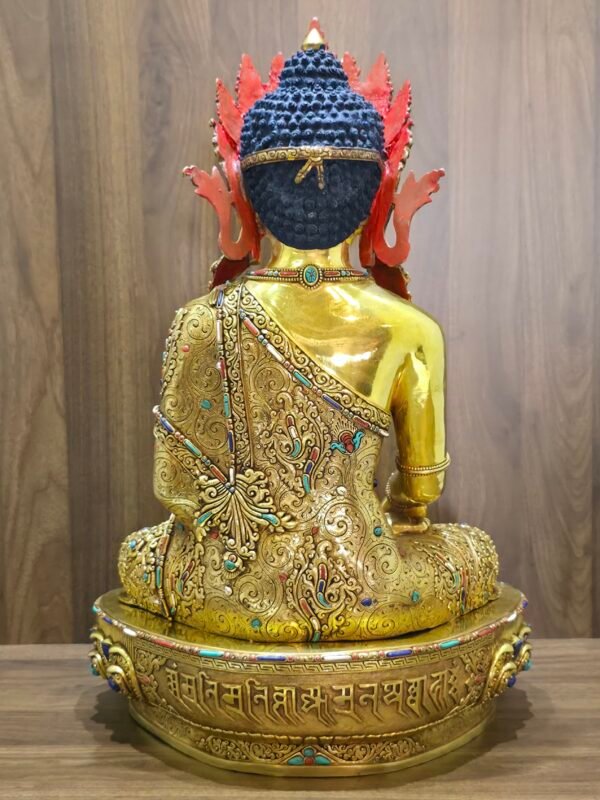Rear view of Crown Shakyamuni Buddha statue showing engraved robe, red back ornament and inscription on the gold plated base.
