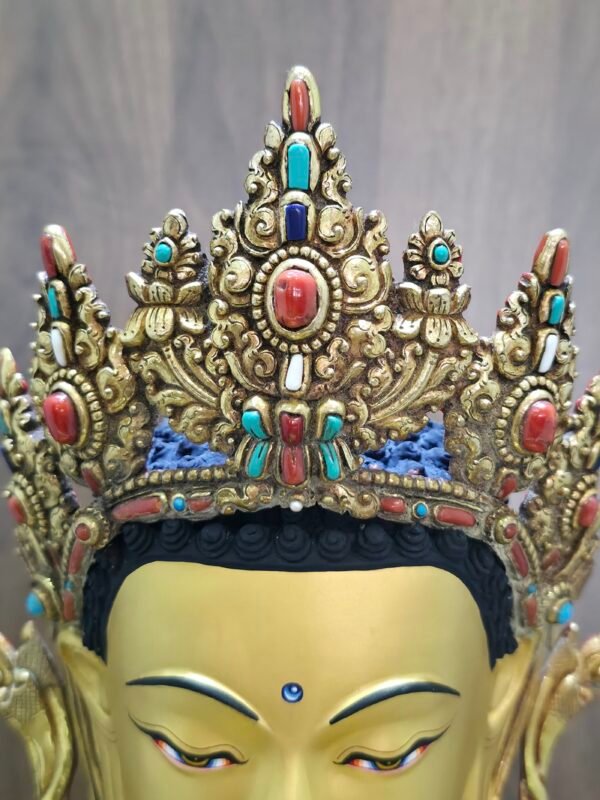 Close up of the ornate crown on Crown Shakyamuni Buddha statue with red coral, turquoise, lapis and conch shell details.