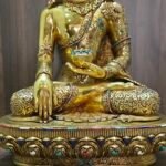 Lower front detail of Crown Shakyamuni Buddha statue showing earth touching hand, alms bowl and decorated base.