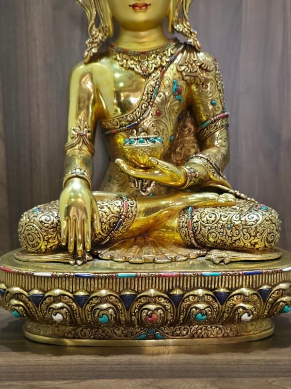 Lower front detail of Crown Shakyamuni Buddha statue showing earth touching hand, alms bowl and decorated base.