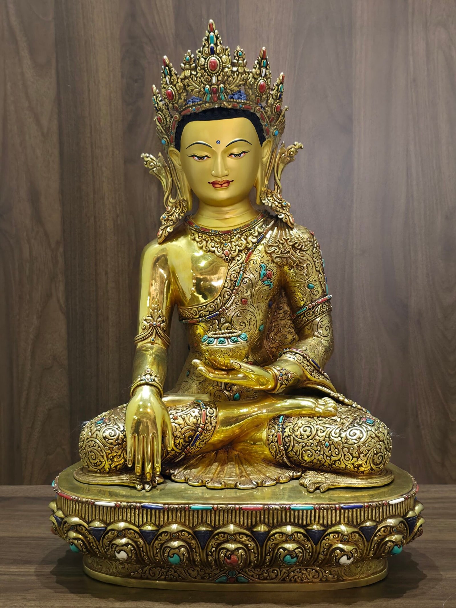 Full front view of Crown Shakyamuni Buddha statue seated on a decorated base with gold plated finish and inlay details.