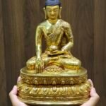 Scale view of Shakyamuni Buddha statue held in two hands showing size and proportions.