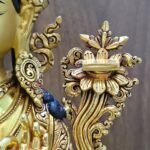 Close-up of the scripture resting on a lotus beside Manjushri’s left shoulder, with detailed petals and curling foliage.