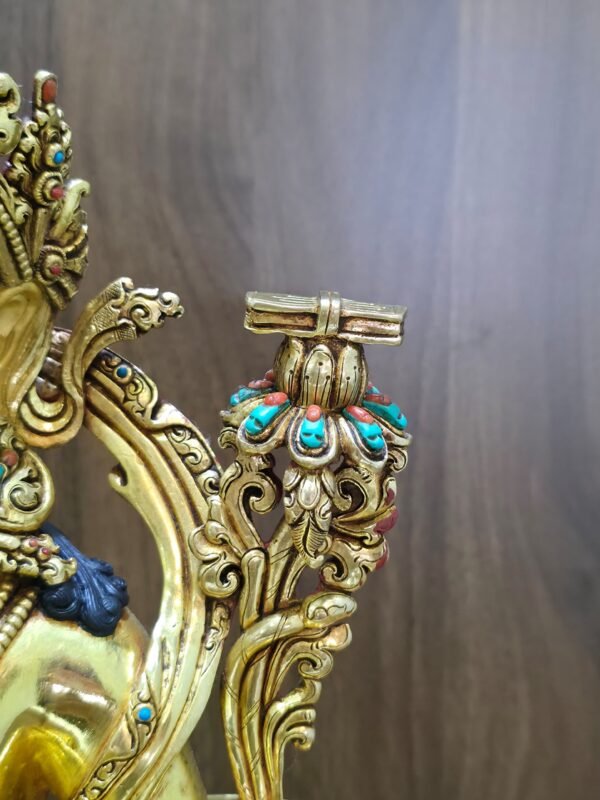 Close-up of the scripture on a lotus beside Manjushri’s left shoulder, with red coral and imitation turquoise accents on the petals.
