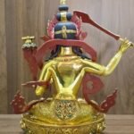 Rear view of Manjushri, showing dark blue hair, red-painted ornament backs, a gold-plated back and engraved garments and pedestal.